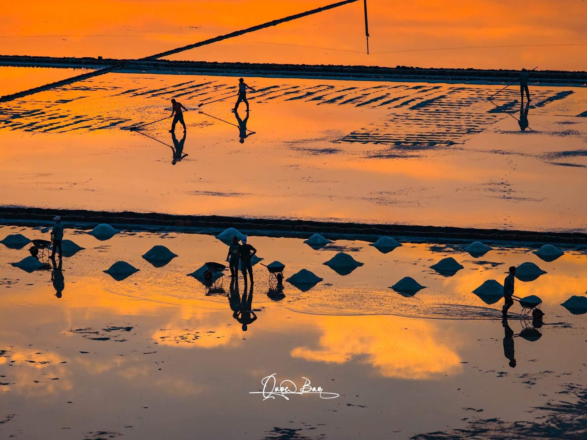 Người làm muối đang làm việc trên đồng muối Hòn Khói. Ảnh: Quốc Bảo.